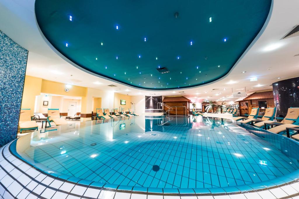 una gran piscina en un hotel con techo azul en Mauritius Hotel & Therme, en Colonia