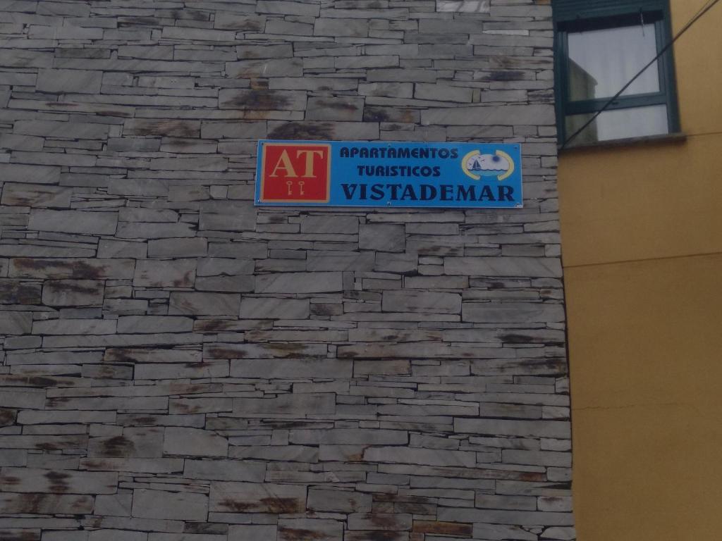 a sign on the side of a brick wall at Apartamentos turísticos Vistademar in Luarca