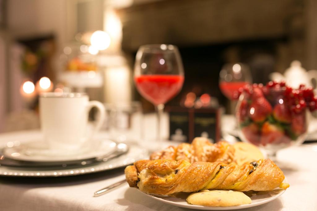 einen Teller mit Essen auf einem Tisch mit einem Glas Wein in der Unterkunft San Michele al Borgo in Castiglion Fiorentino