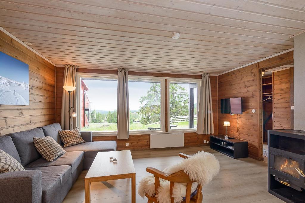 sala de estar con sofá y chimenea en Nordseter Apartments, en Lillehammer
