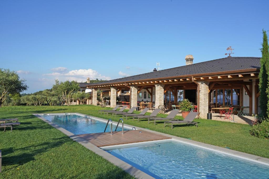 波爾佩納澤德爾加爾達的住宿－Pietra Cavalla - Ranch & Resort，庭院中带游泳池的房子