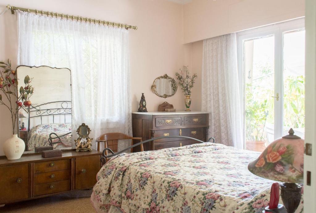 - une chambre avec un lit, un miroir et une fenêtre dans l'établissement Family apt with garden next to the sea, à Athènes