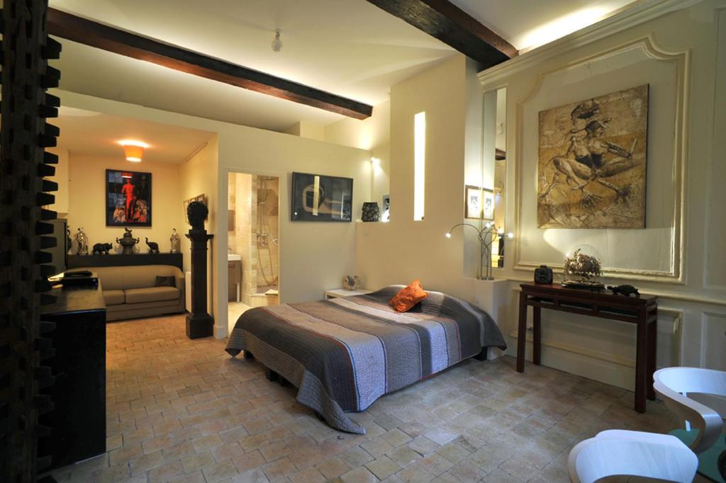 een slaapkamer met een bed en een tafel in een kamer bij Chambres d'hôtes Artelit in Lyon
