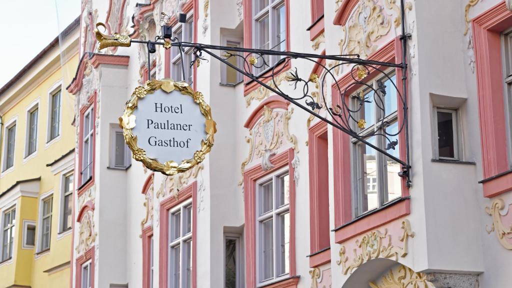 a sign hanging on the side of a building at Hotel Paulanerstuben in Wasserburg am Inn