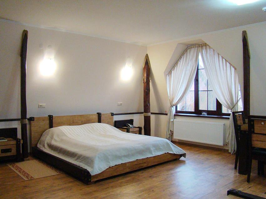 a bedroom with a large bed and a window at Hotel Zolota Pidkova in Kozlin