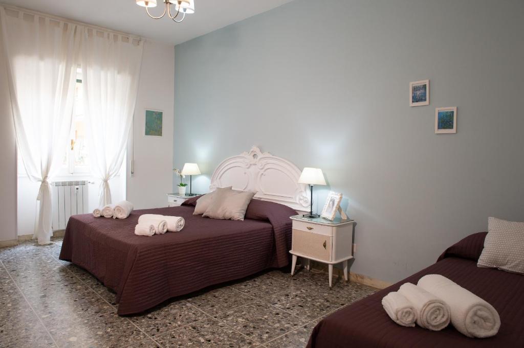 a bedroom with two beds with towels on them at House Bonifacio in Rome