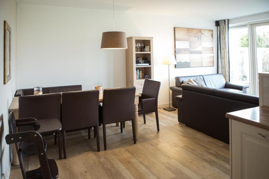 a kitchen and living room with a table and chairs at Weidevilla 14 auf Ameland in Hollum