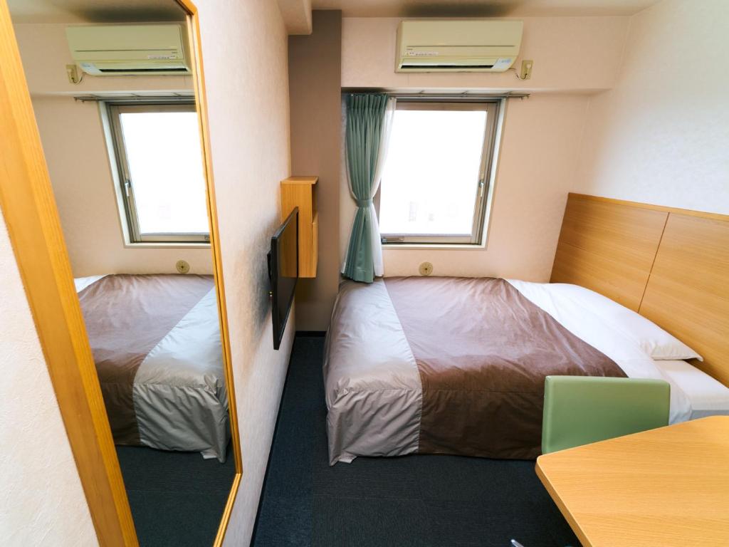 Postel nebo postele na pokoji v ubytování Super Hotel Matsuyama