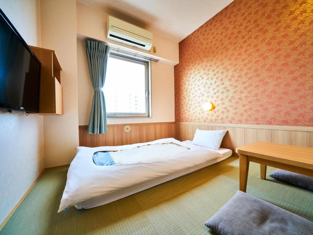 Postel nebo postele na pokoji v ubytování Super Hotel Matsuyama