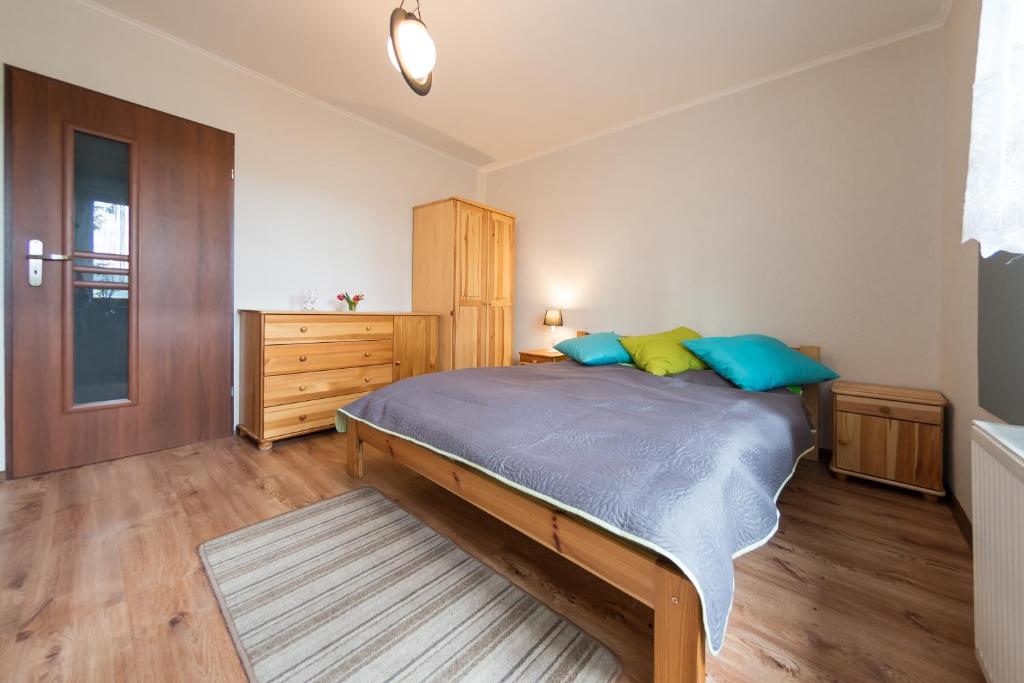 sypialnia z łóżkiem z niebieskimi i żółtymi poduszkami w obiekcie Willa Melisa w Wiśle