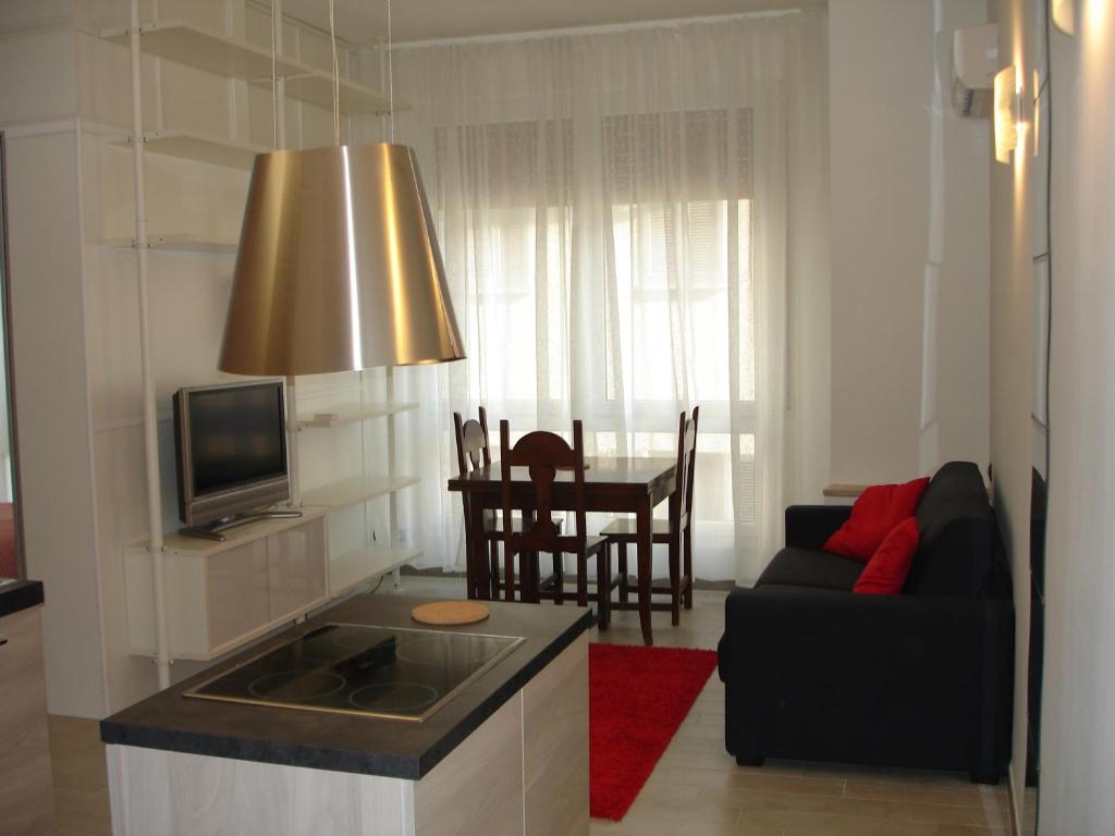uma sala de estar com um sofá e uma mesa com uma televisão em Milan City Center Apartment em Milão