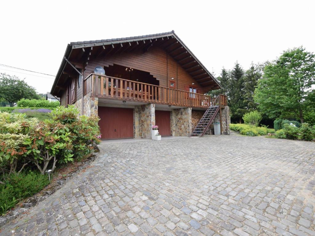 ein Haus mit einer Terrasse und einer Backsteineinfahrt in der Unterkunft Splendid Chalet in Durbuy with Garden in Durbuy