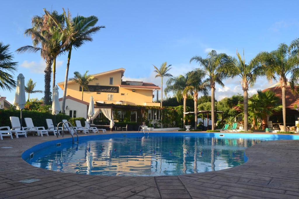 Hotel Club Costa Smeralda في كابو فاتيكانو: مسبح بالنخيل ومبنى