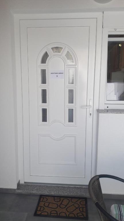 a white door with a window in a room at Apartman BARAKA in Šibenik