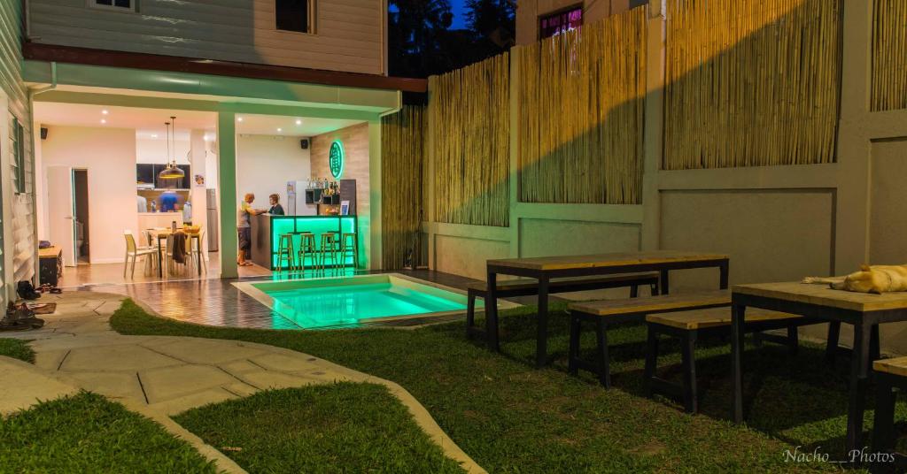 a backyard with a pool and two tables and benches at Kame House Hostel in El Nido