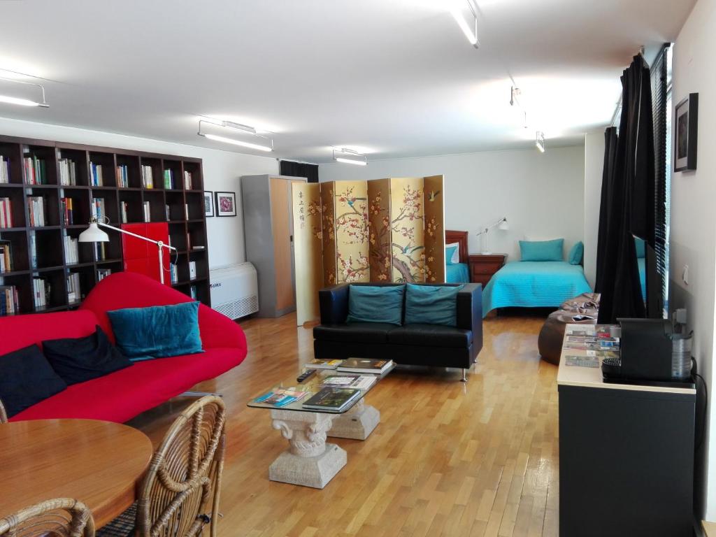 a living room with a red couch and blue chairs at Vila Real Loft 360º in Vila Real