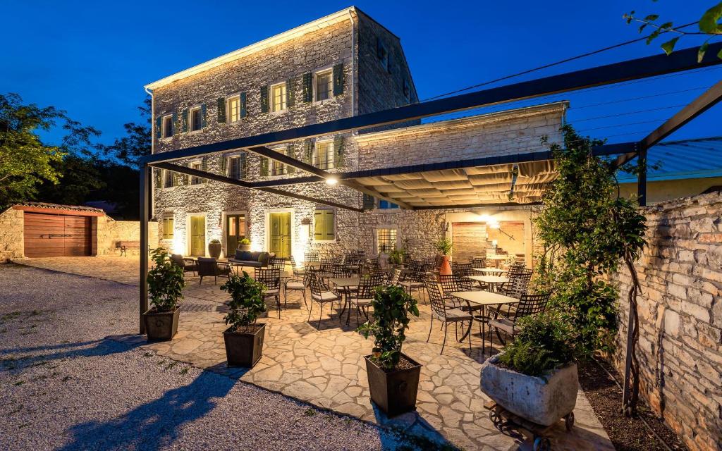 patio ze stołami i krzesłami oraz budynek w obiekcie Relais and Wine San Tommaso w mieście Bale