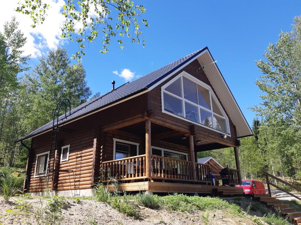 a log cabin in the woods with a large deck at Hiekkaranta Holiday Home in Parikkala