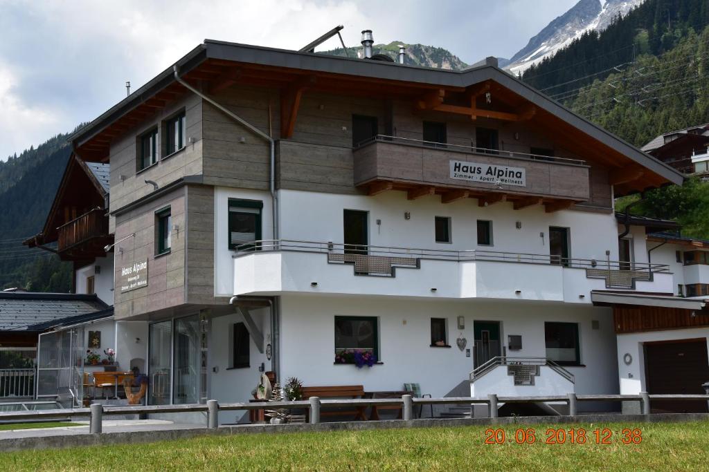 Großes weißes Gebäude mit Balkon in der Unterkunft Gästehaus Alpina in Sankt Anton am Arlberg