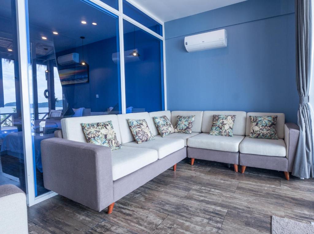 a couch and two chairs in a room with blue walls at Sara Resort in Koh Rong Sanloem