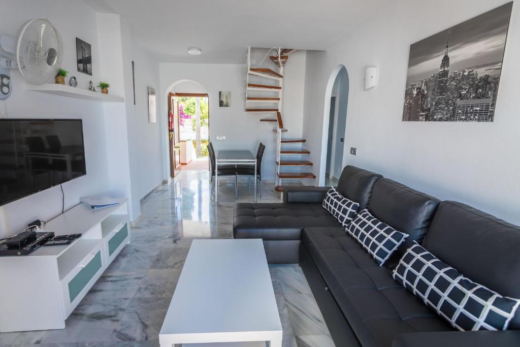 a living room with a couch and a table at Apartamentos Las Rosas de Capistrano in Nerja