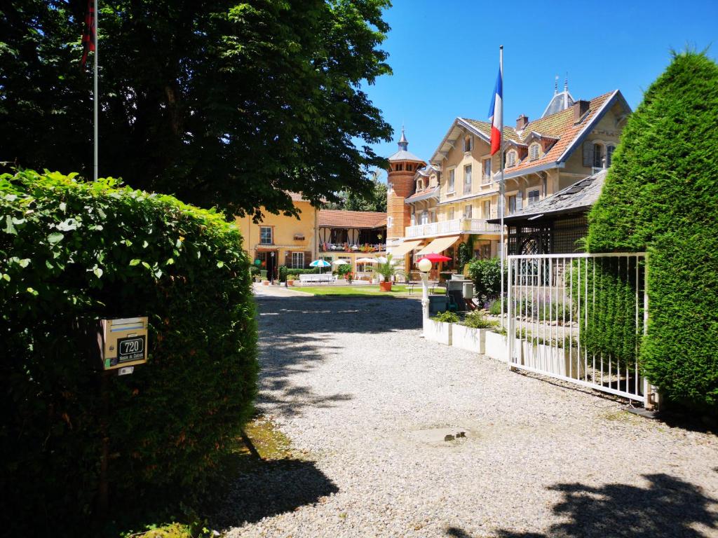a house with a white fence and a hedge at La Garde Chambres d'hôtes in Charancieu