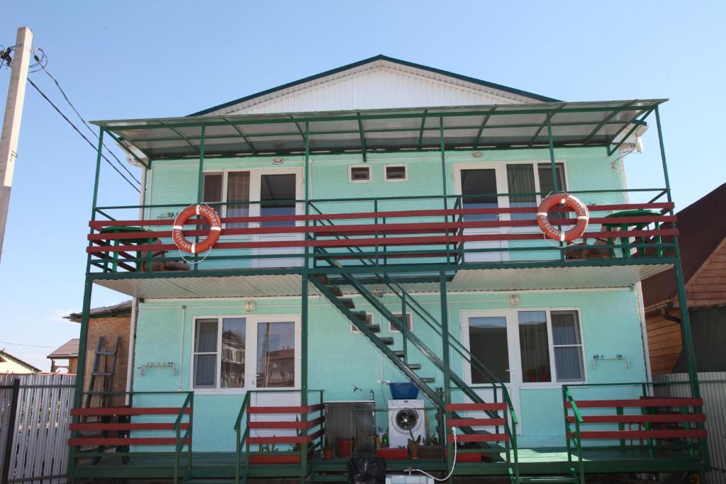 una casa con escaleras rojas a un lado. en Guest House Lanka en Golubitskaya