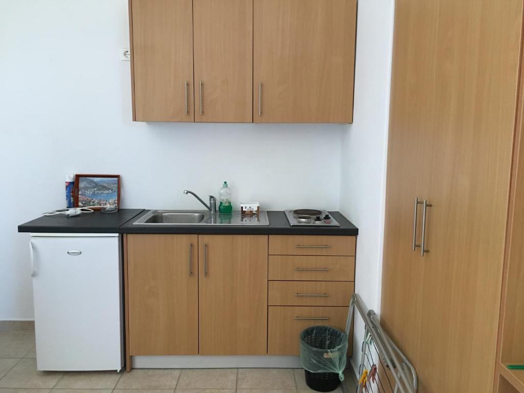 a small kitchen with a sink and a refrigerator at Eugenia travasarou sea view appartments in Diakofti