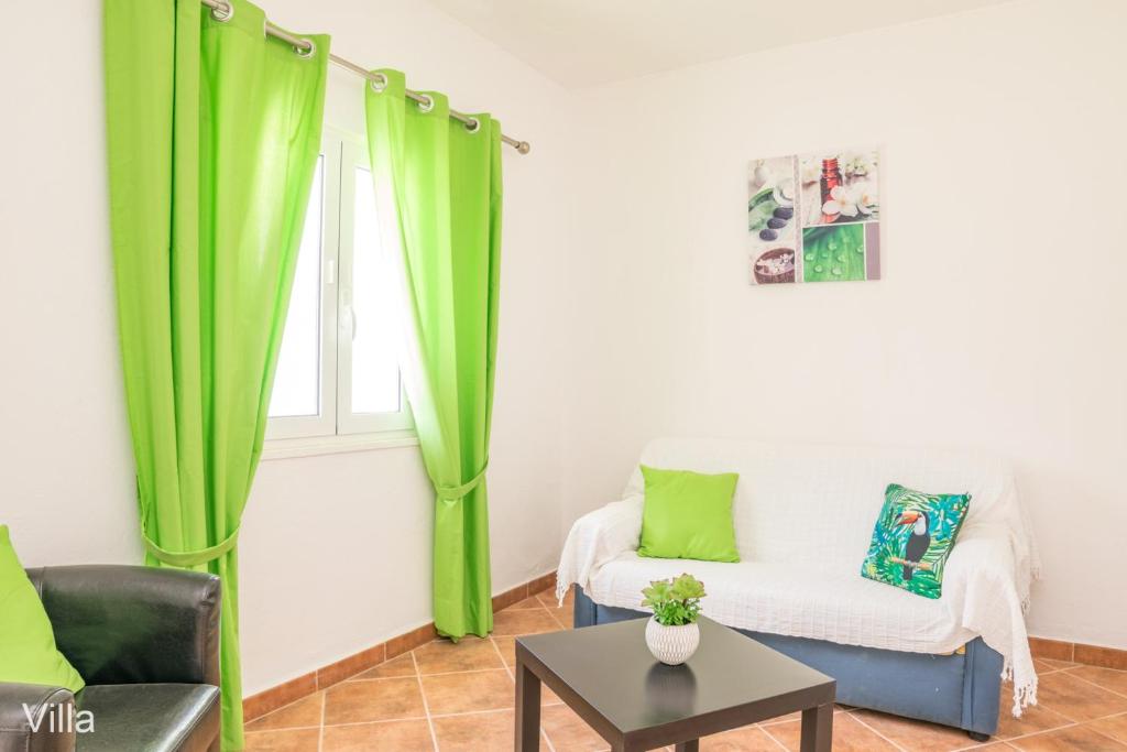 sala de estar con cortinas verdes y sofá en Akivillas Lagos Garden II, en Lagos