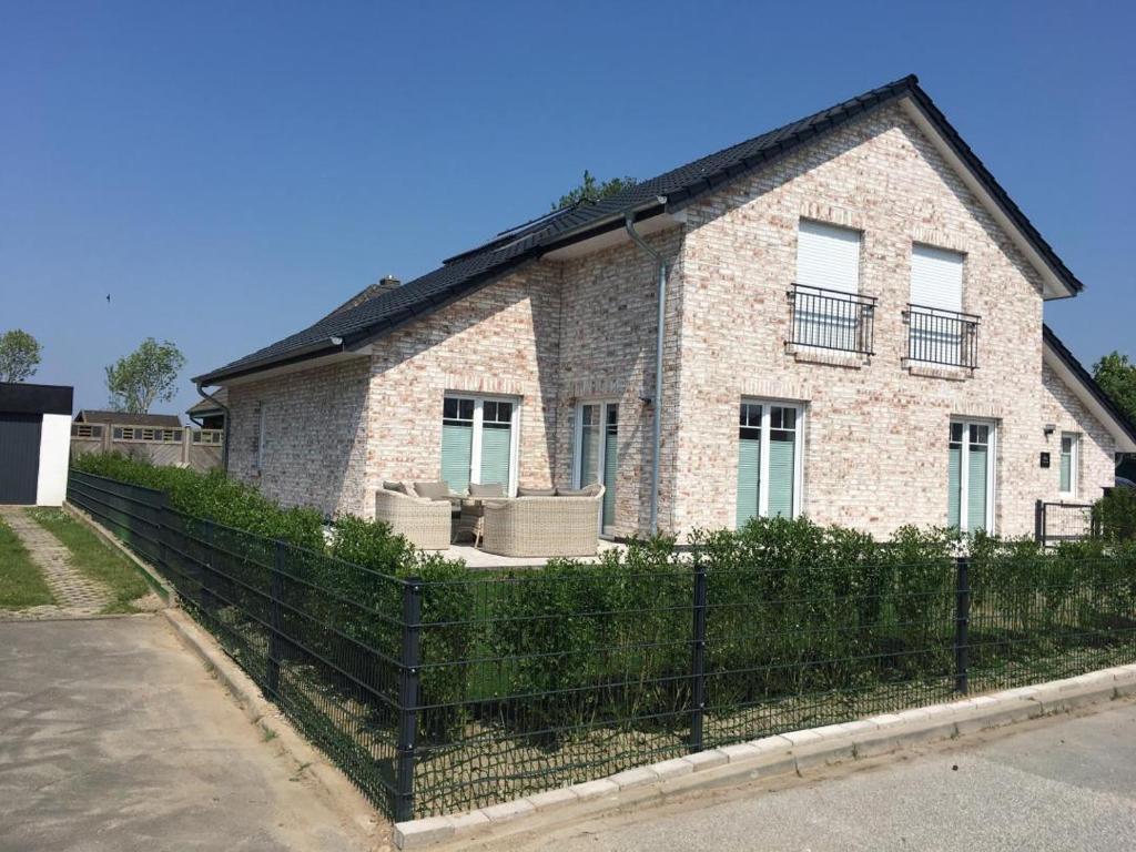 a brick house with a fence in front of it at Ferienhaus Merzijana in Büsum