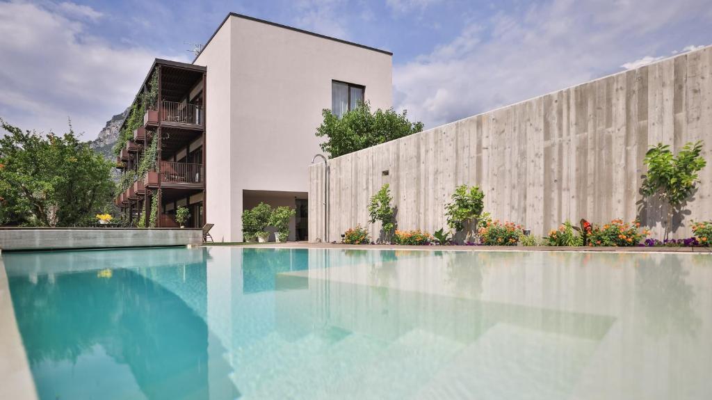 a swimming pool in front of a building at SOLeARIA residence in Riva del Garda