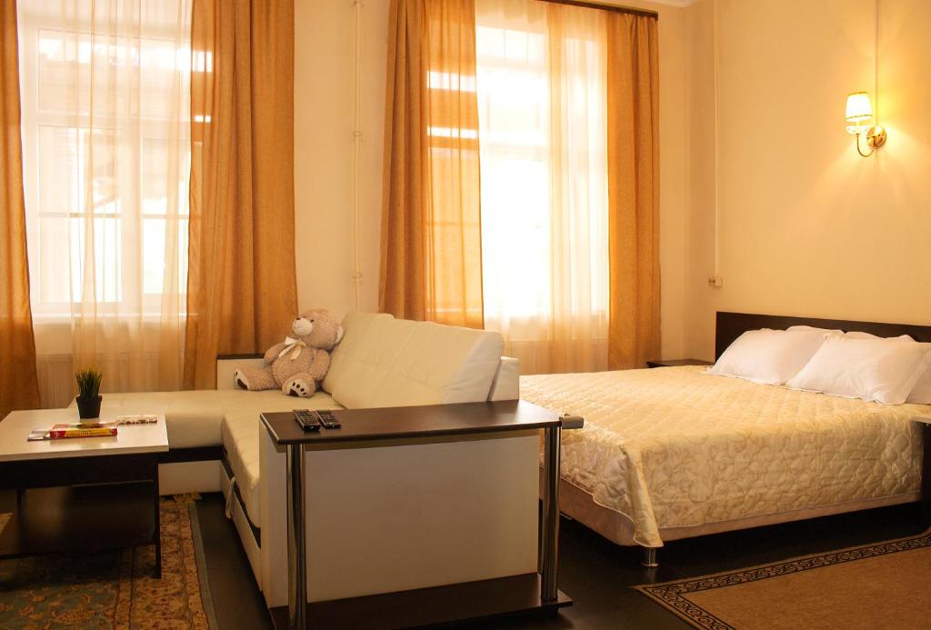 a hotel room with two beds and a teddy bear at Yellow Hotel in Saint Petersburg