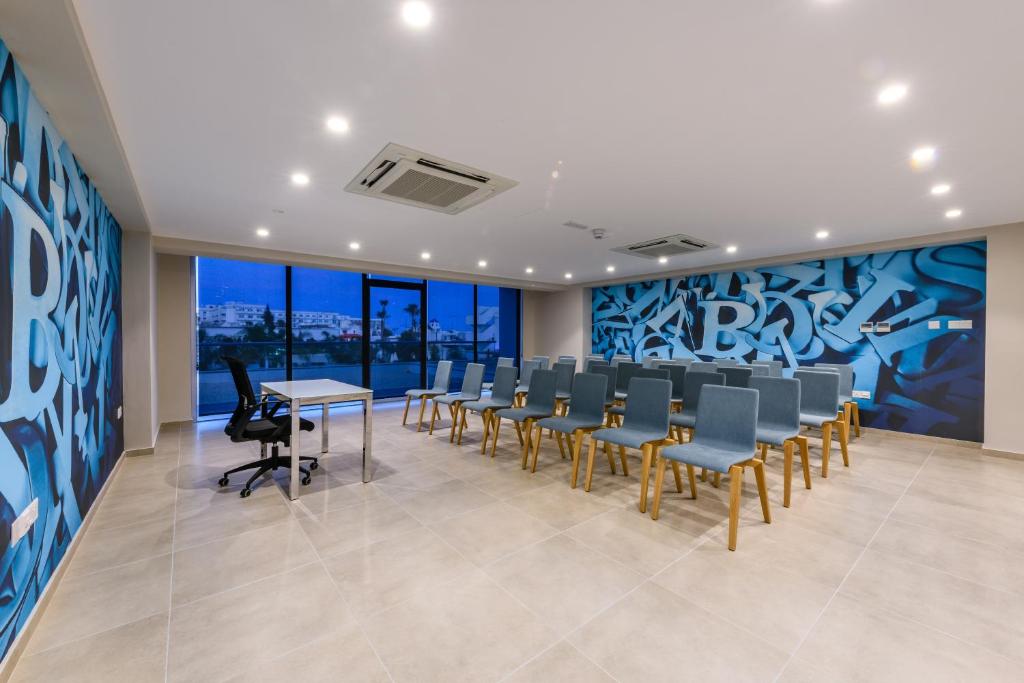 a conference room with chairs and desks and a wall with graffiti at Seasons Hotel (Adults Only) in Ayia Napa