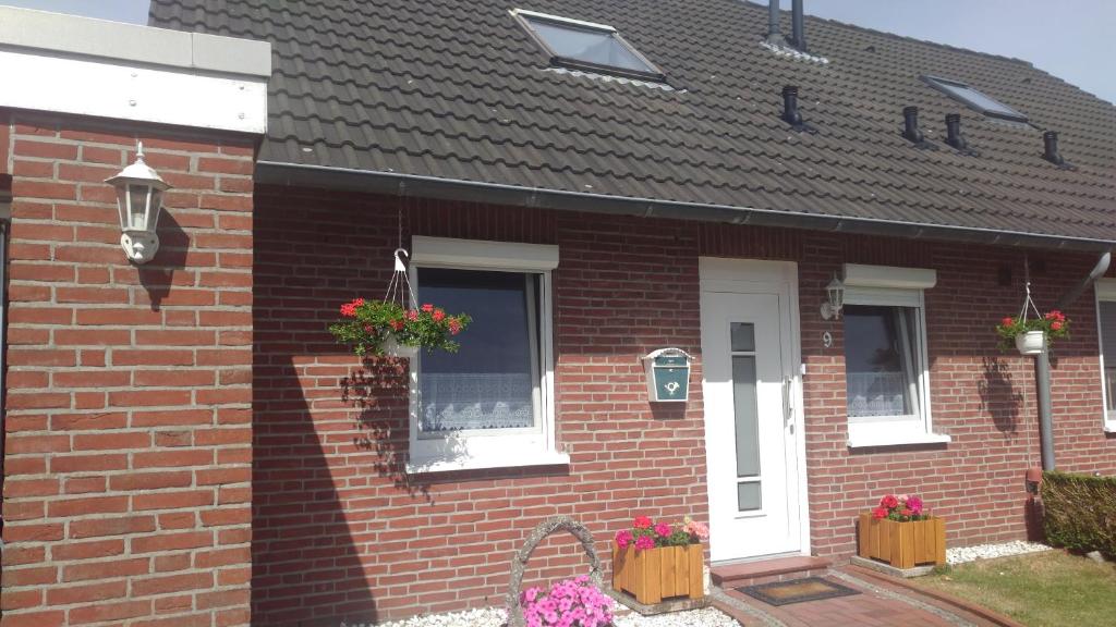 een bakstenen huis met bloembakken op de ramen bij Ferienhaus "Buchfink" in Berumbur
