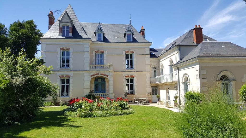 a large house with a yard in front of it at La Roseraie in Neuville-du-Poitou