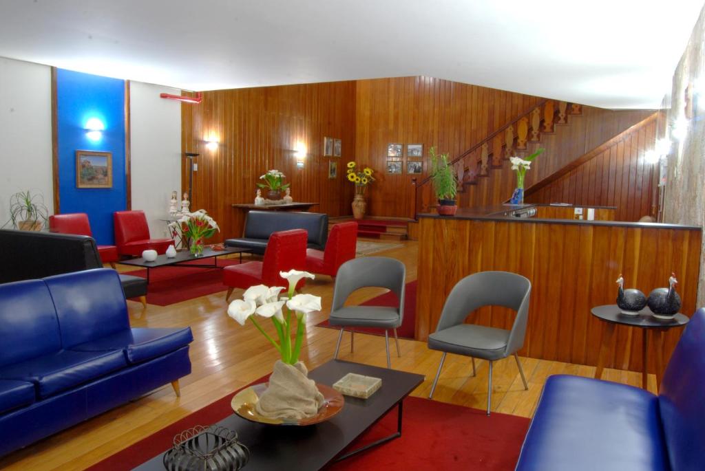 a waiting room with blue and red chairs at Hotel Tijuco Turismo in Diamantina
