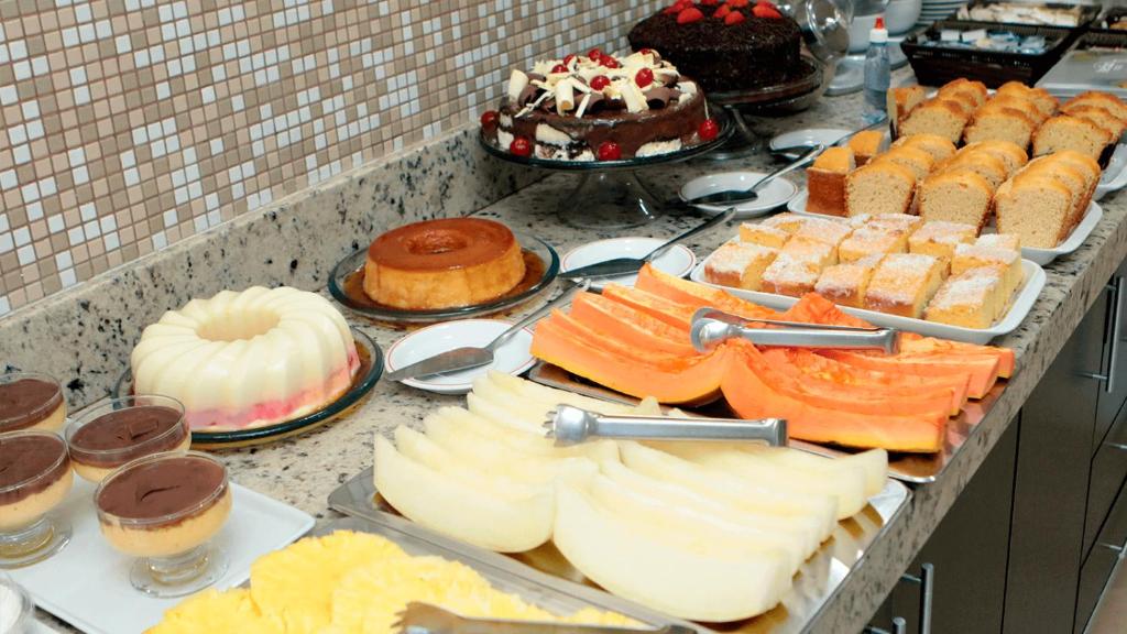a buffet filled with different types of cakes and pastries at Hotel Sul Três Lagoas in Três Lagoas