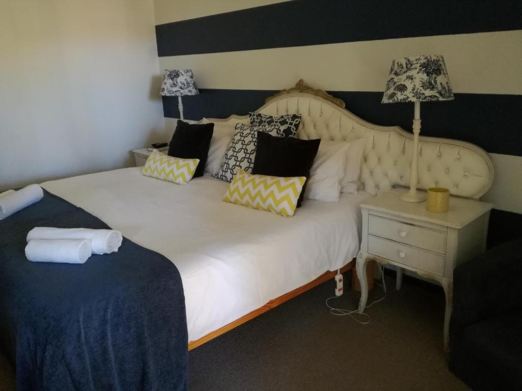 sypialnia z dużym białym łóżkiem z poduszkami w obiekcie Die Kersiehuis w mieście Ficksburg