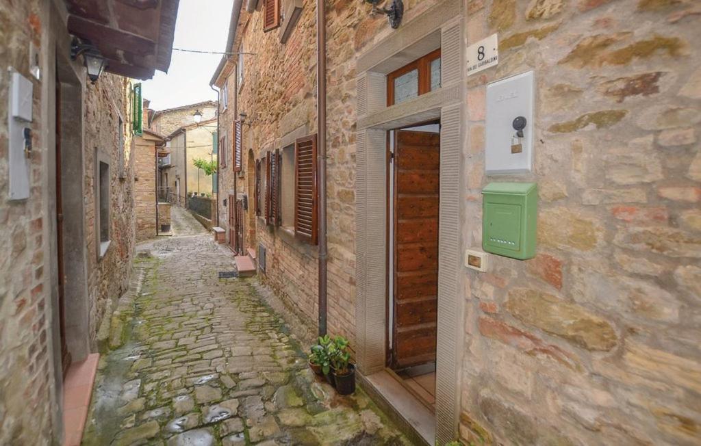 un callejón de piedra con un buzón verde en un edificio en Casa Lugnano en Città di Castello