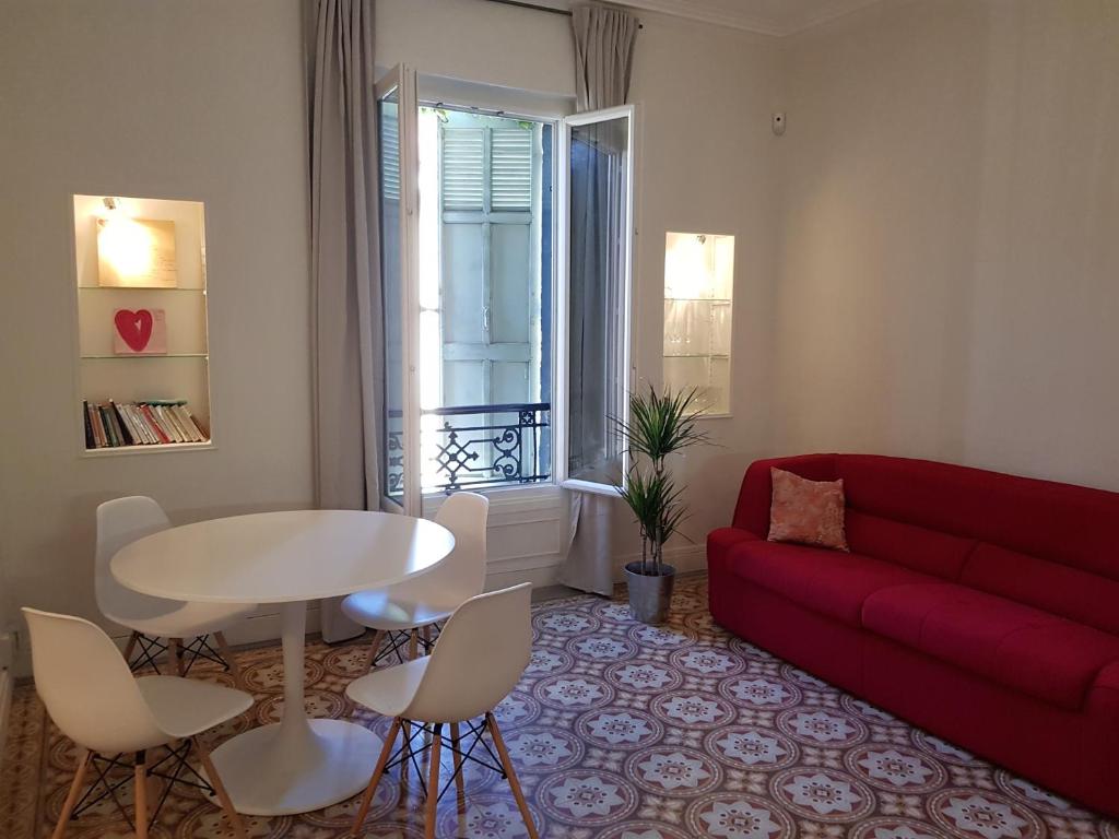 un salon avec un canapé rouge et une table dans l'établissement Vintage Vieux-Port Apartment, à Marseille