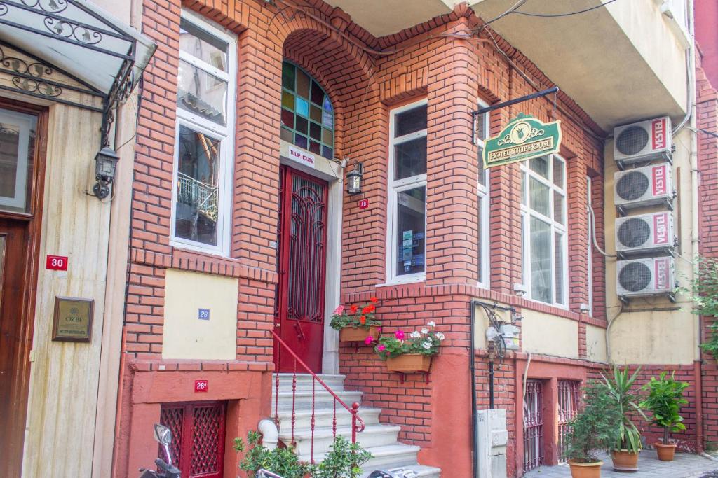 ein rotes Backsteingebäude mit einer roten Tür und einer Treppe in der Unterkunft Hotel Tulip House in Istanbul