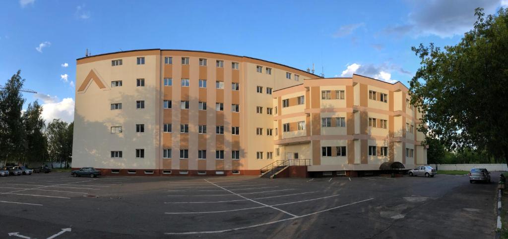 un gran edificio con un estacionamiento delante de él en Hotel Kupavna en Staraya Kupavna