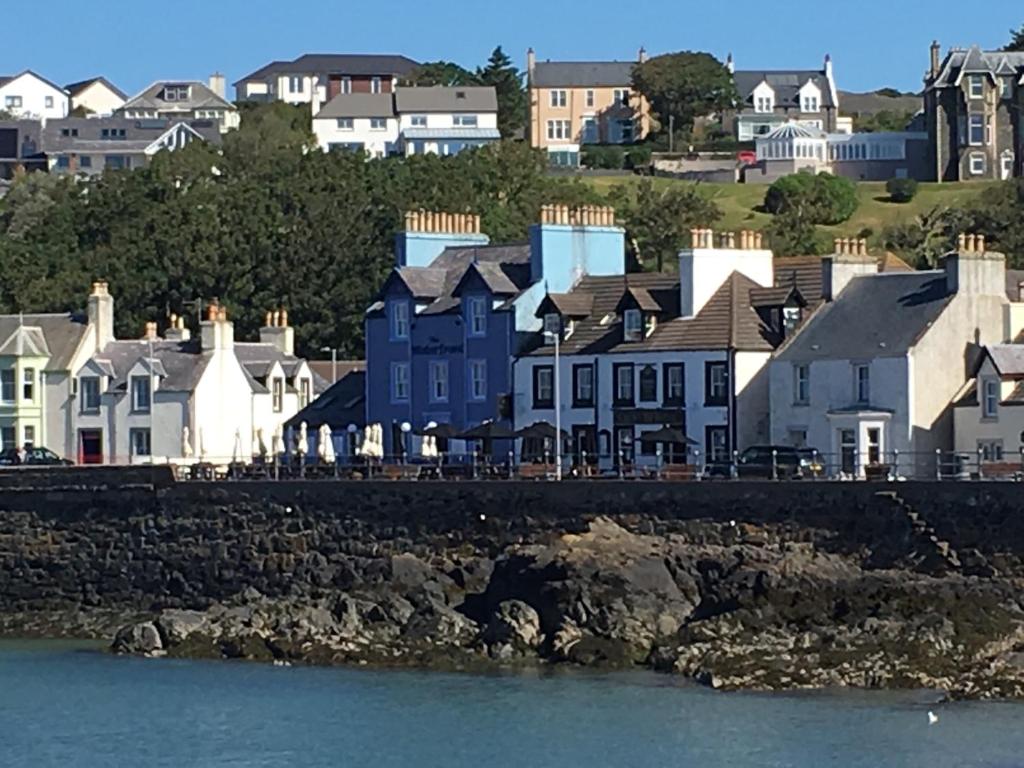 a group of houses next to the water at The Waterfront Seafront hotel and Bistro in Portpatrick