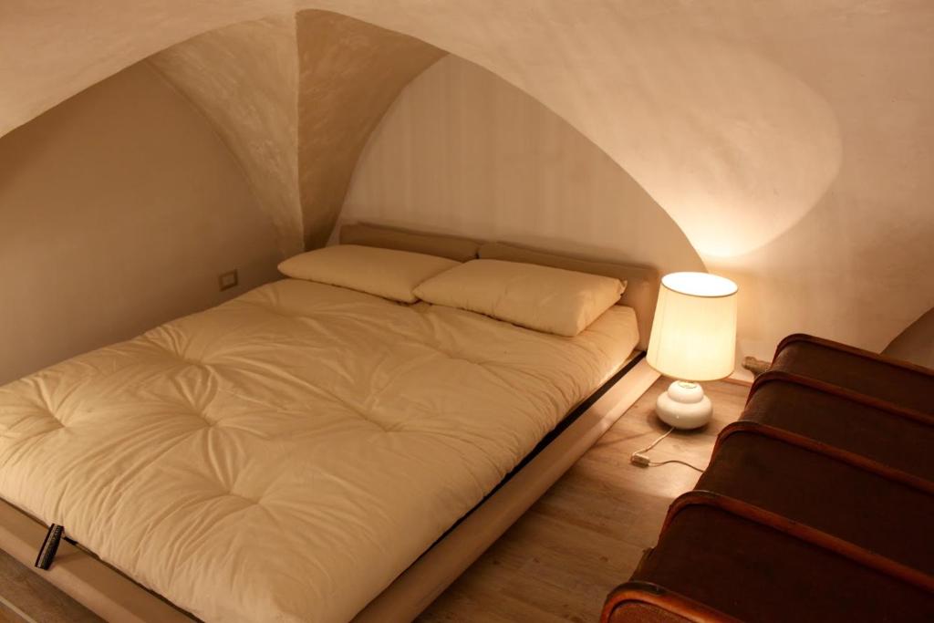 a small bedroom with a bed and a lamp at Casa enzo in Arezzo