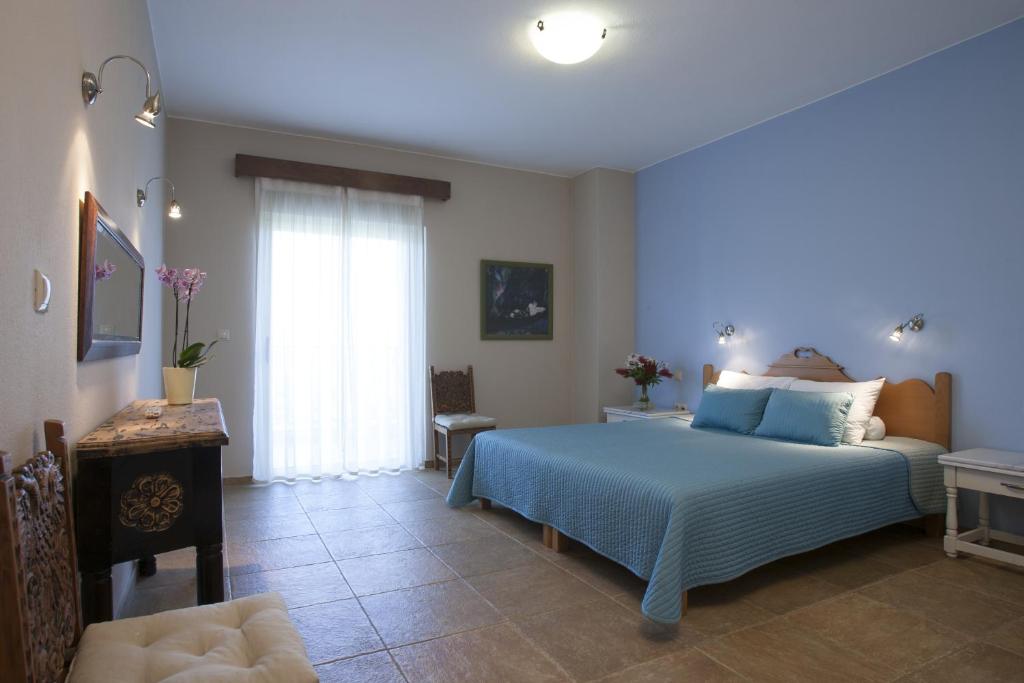 a bedroom with a blue bed and a window at Istron Maisonettes with private pool in Istro