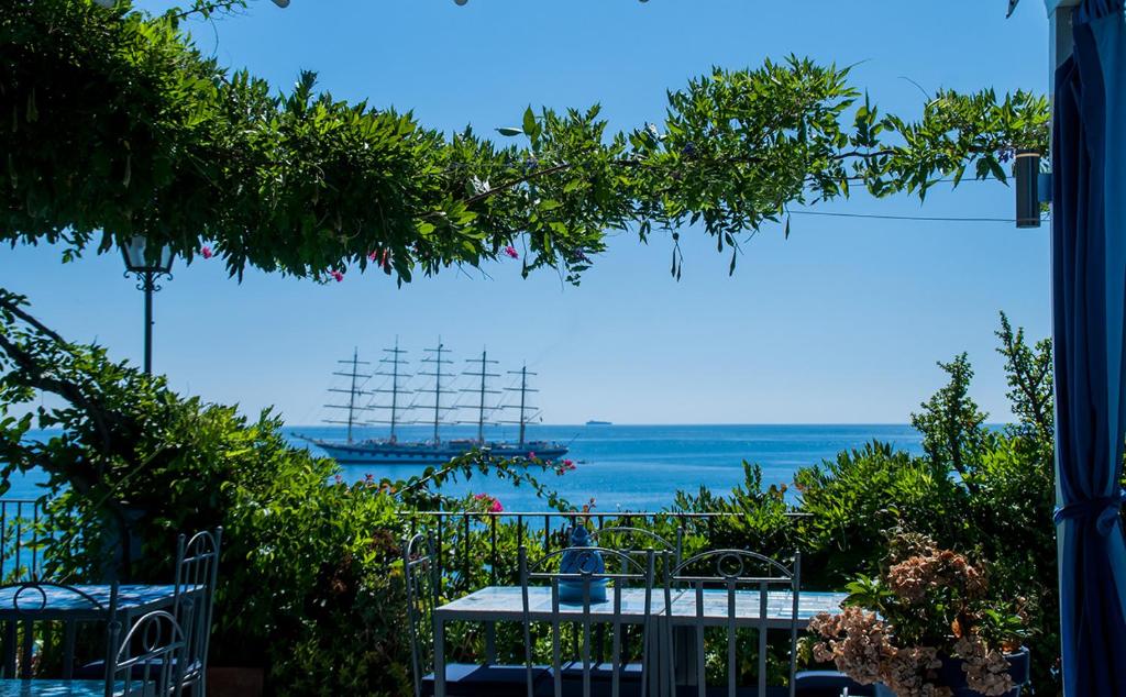 a view of the ocean from a patio at Hotel Palladio in Giardini Naxos