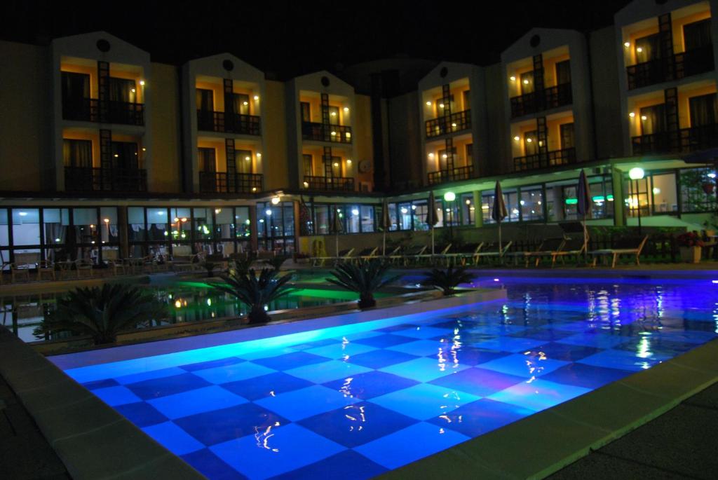 a swimming pool in front of a building at night at River Park Hotel in Ameglia