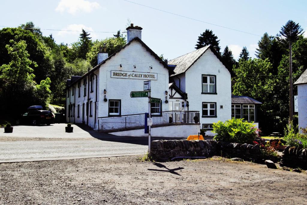 a white building with a sign on the side of it at Bridge of Cally Hotel in Blairgowrie