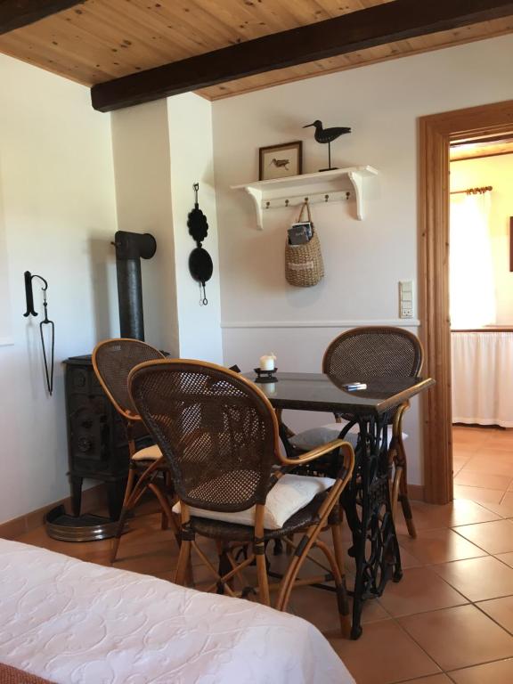 a room with a table and chairs and a stove at Rosengave in Alsted