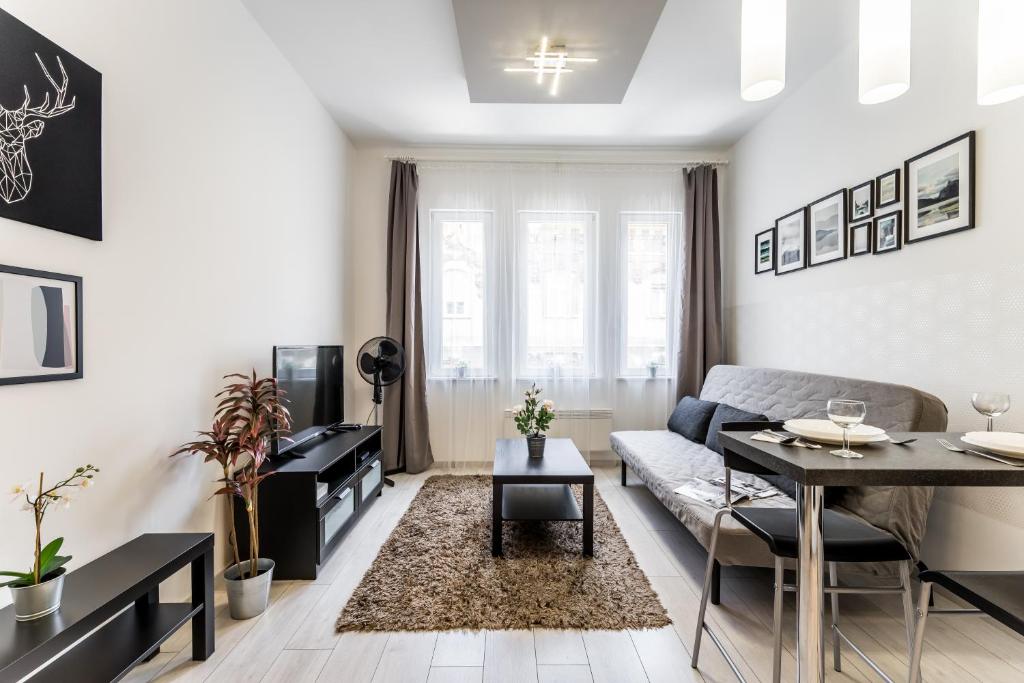 a living room with a couch and a table at Fleur Créme Apartment in Budapest